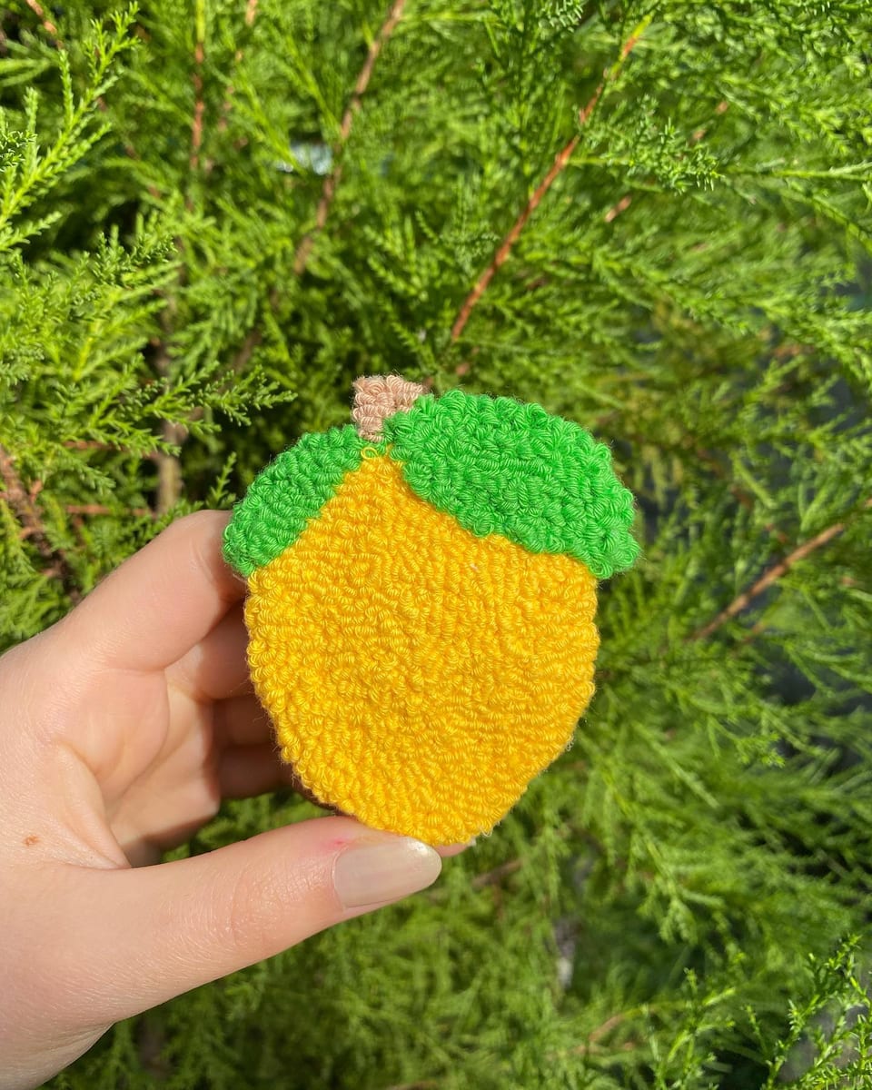 Yeşil yapraklı sarı limon punch nakış toka, elde yakın çekim