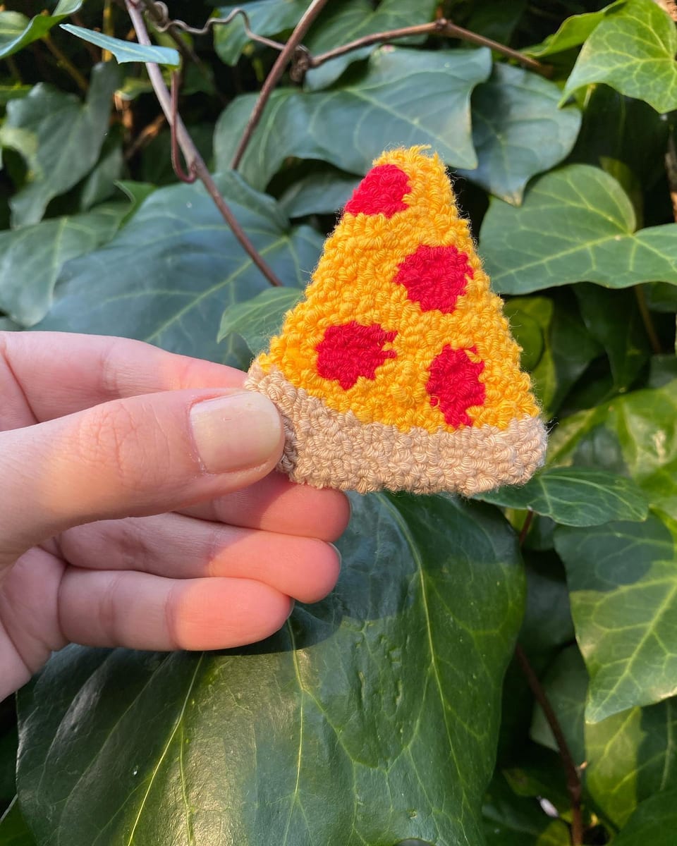 Sarı peynirli pizza dilimi punch nakış toka, elde yakın çekim