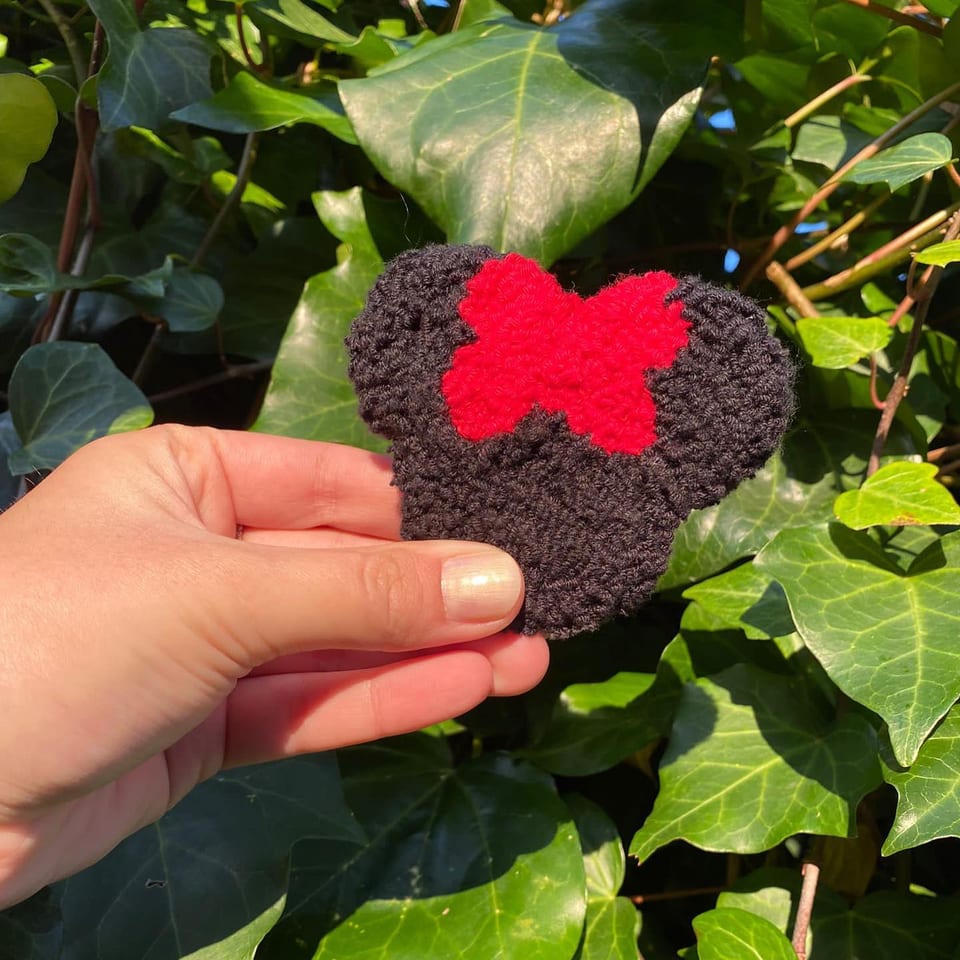 Siyah kulaklı silüet ve kırmızı fiyonklu Minnie Mouse punch nakış toka, elde yakın çekim