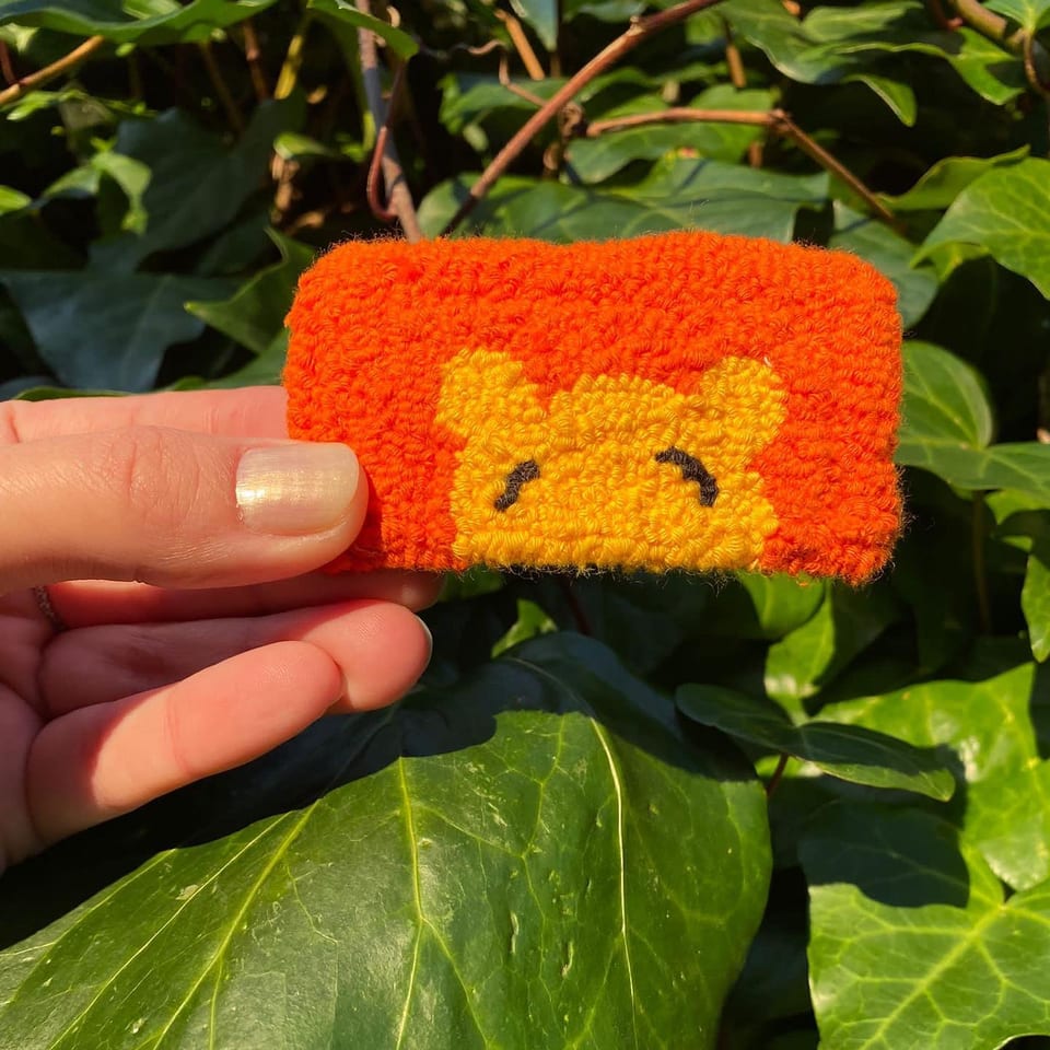 Turuncu dikdörtgen zemin üzerinde sarı Winnie the Pooh punch nakış toka, elde yakın çekim