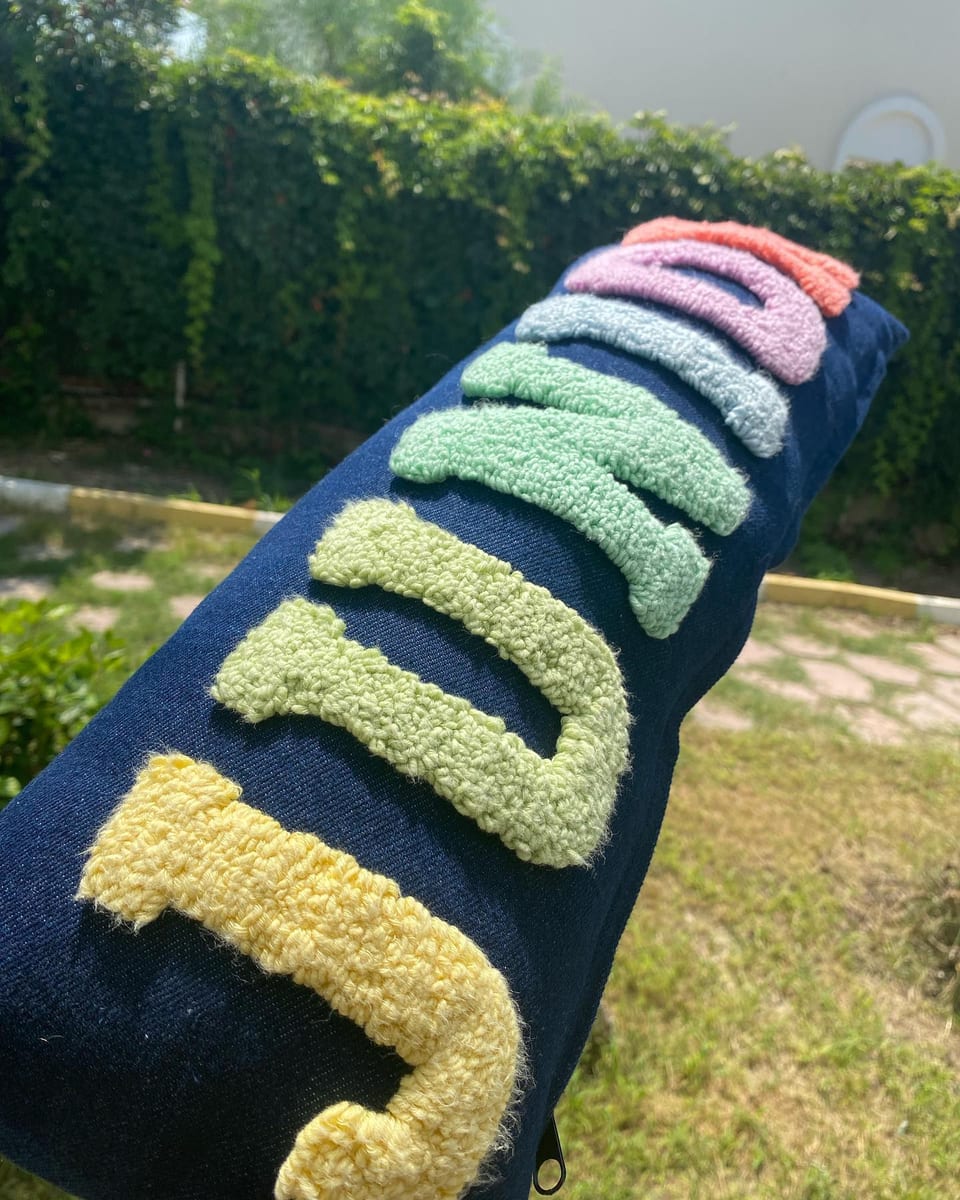 Denim yazılı kırlentte renkli harflerin punch nakış dokusu, yakın çekim